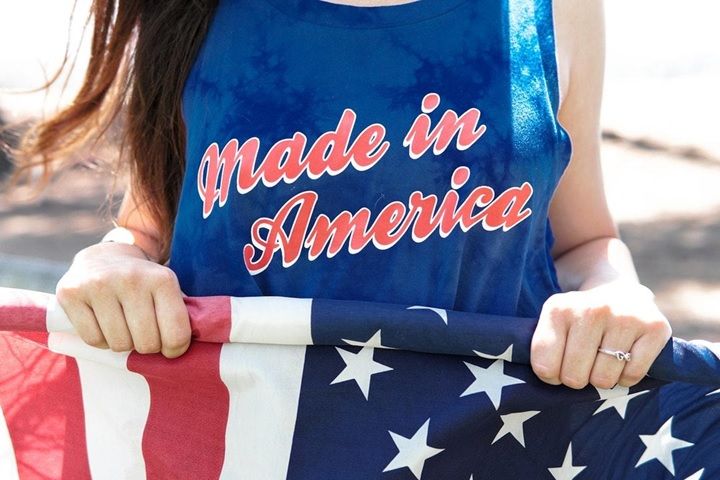 Person with a Made in America shirt holding an American Flag