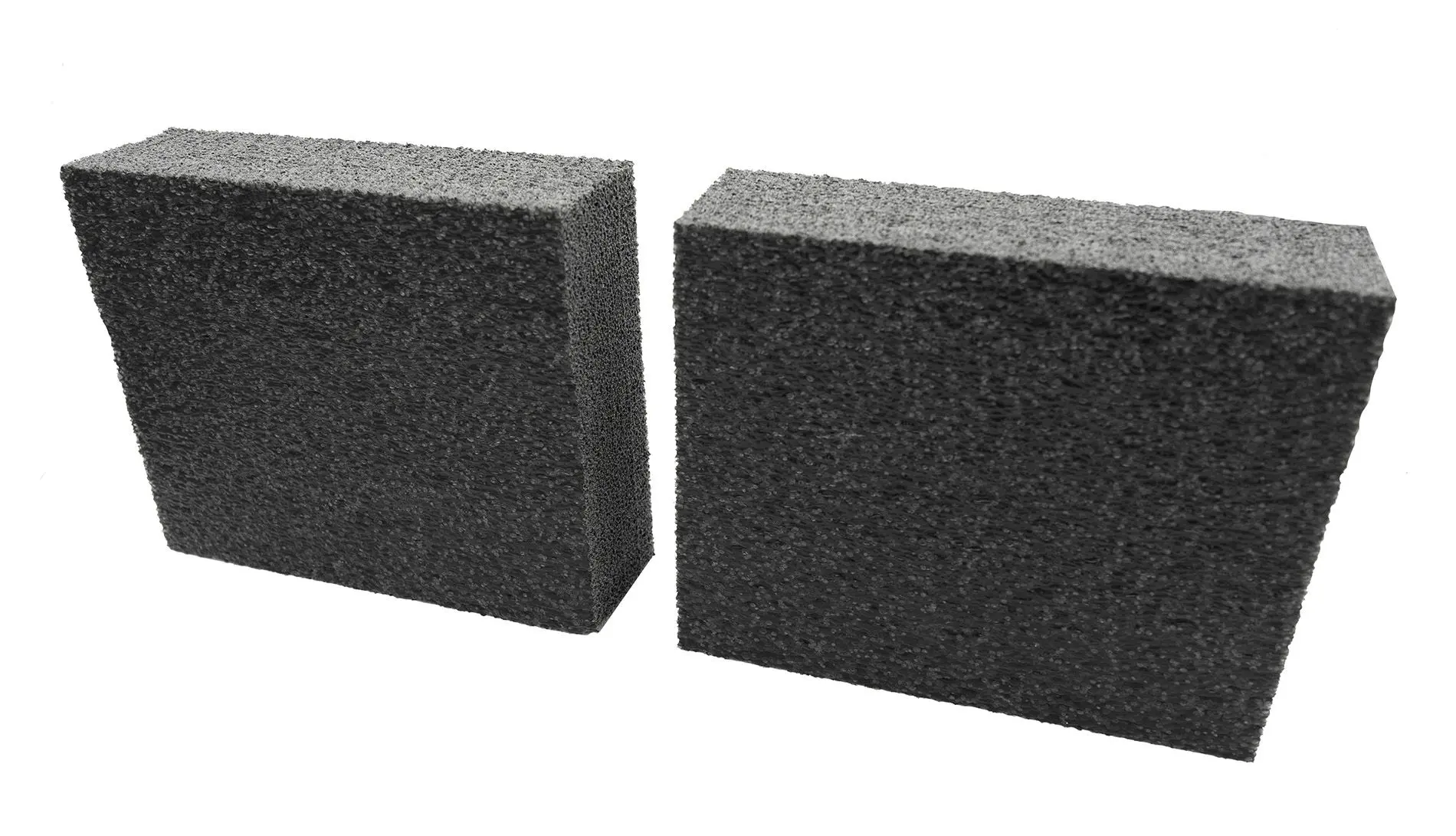 Two rectangular black pumice stones on a white background.