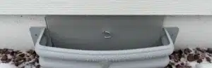 Exterior below the ground foundation vent cover. Gray vent cover in snow protection