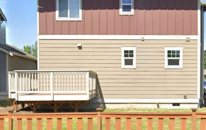 Side of house with small wooden deck.
